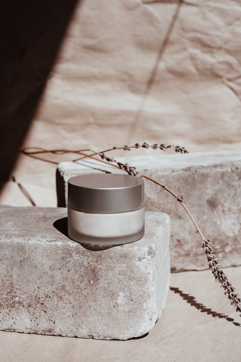 White Cosmetic Container on Rock with Lavender